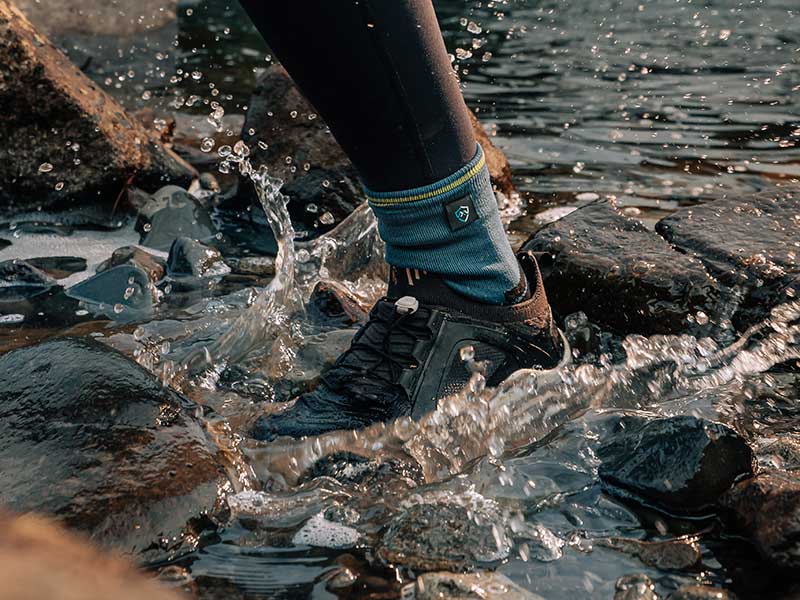 trail runner across the water splash wearing waterproof running socks