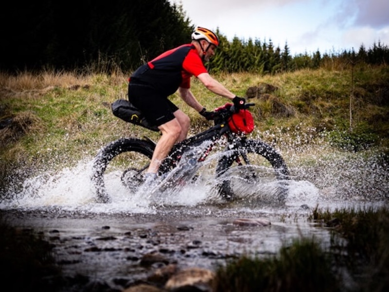 A bikepacker crossing puddles in Cateran Dirt Dash